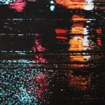Streetcar tracks cut up de shiny colours of reflected neon and traffic lights; a feast of orange, red, pink and blue on a rainy night.