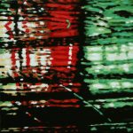 Neons on a rainy night create an abstract piece of art in red and green